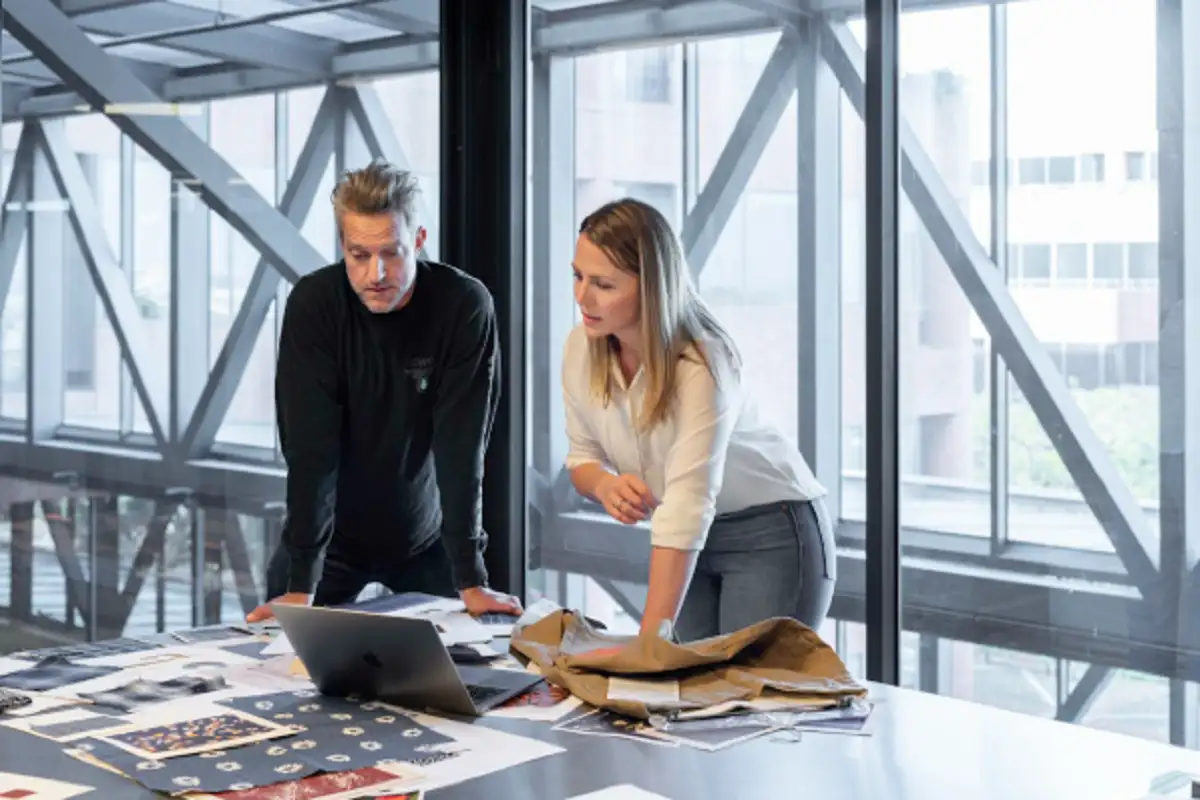 Two professionals leveraging a deal management system to enhance team collaboration and accountability in deal closure